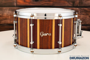 GURU DRUMS 13 X 7 BUBINGA, MAPLE & PURPLEHEART STAVE SNARE DRUM (PRE-LOVED)